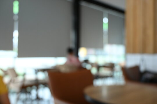 softy blurred view of a modern cafe or lounge interior featuring comfortable chair and round table