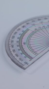 Vertical video: Protractor for mathematics. Semicircle measuring tool, student math drawing tool.