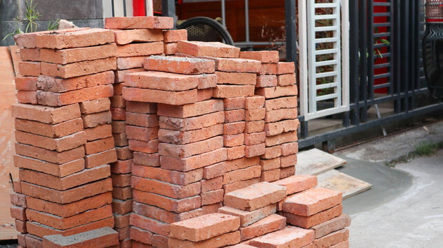 Large stack of red clay bricks at an outdoor construction site