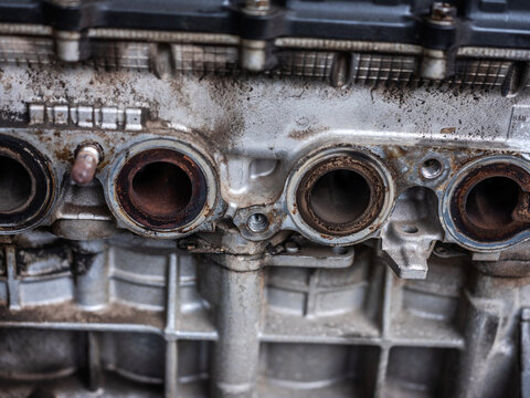 Close up of dirty engine cylinder head exhaust ports with carbon buildup