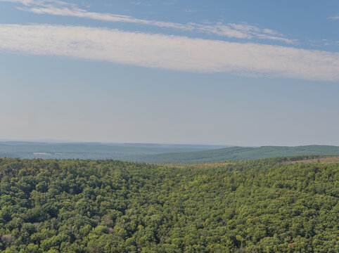 Rolling forested hills and valley landscape under blue sky