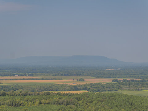 Landscape view of fields and forest with distant mountain