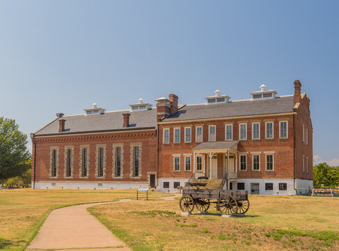 Historic brick building with wagon on lawn