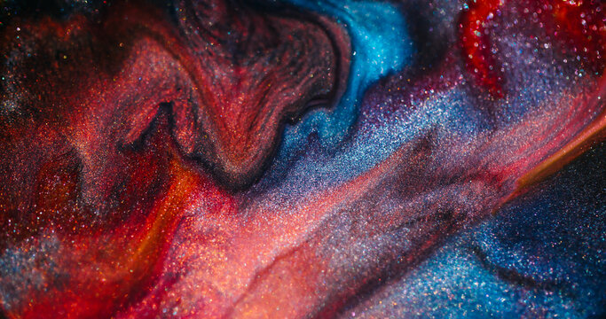 Ink spill. Sparkling fluid. Defocused blue orange color glitter mix acrylic bright texture floating on abstract marble art background.