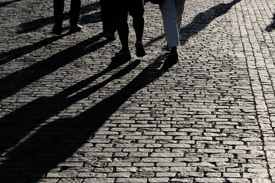 Schatten einiger Spazierg&auml;nger in der Altstadt von Prag bei Sonnenuntergang. Platz f&uuml;r eigenen Text im unteren Bereich
