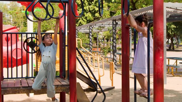 Two Asian Girls Playing on Monkey Bars at Lumpini Park
