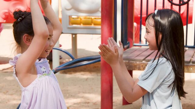 Two Young Asian Girls Playing Hand Clapping Games at Playground