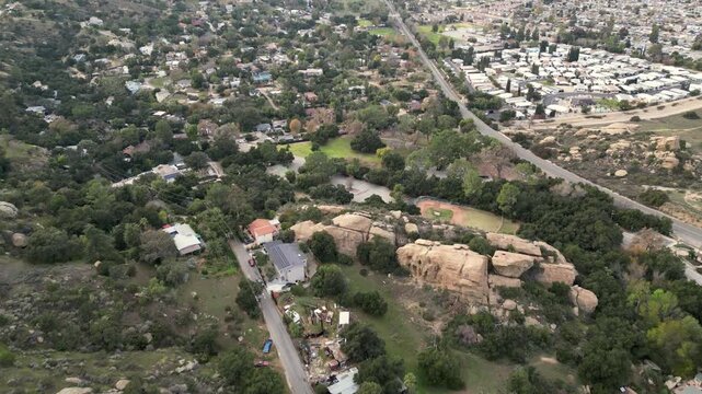 Aerial over railroad tracks, the Santa Susana Park baseball diamond and knolls in the east side of Simi Valley, California.
