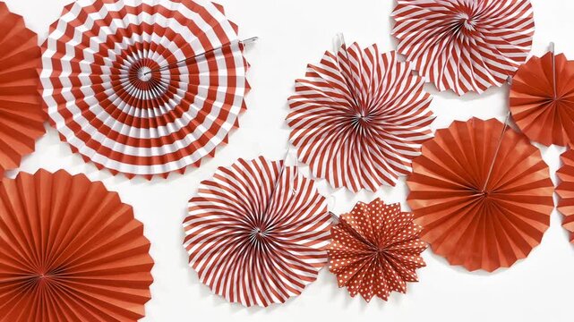 Red and white paper fan decorations on white background. Festive circular party ornaments for Chinese New Year, Christmas, birthday celebration, carnival, and festival backdrop