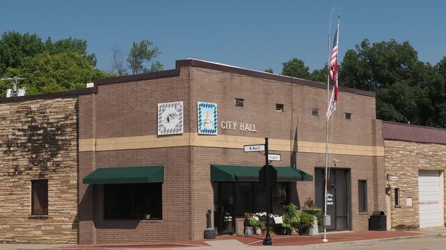 Exterior view of a brick City Hall building with flags