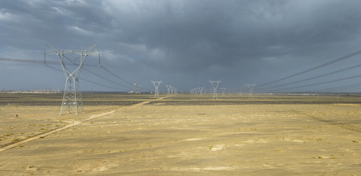 High-Voltage Transmission Towers Stretching Across Desert Gobi at Dusk