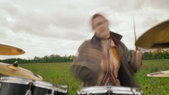 Caucasian woman playing drum kit passionately in meadow. Footage ideal for indie music video production, youth culture campaigns, festival promos, and creative audio branding