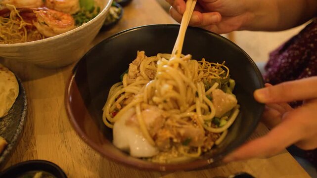 Person Mixing Mandalay Mee Shay Rice Noodles with Chopsticks