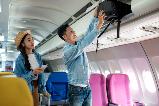 Young Travelers Packing and Organizing Luggage Inside Airplane Cabin