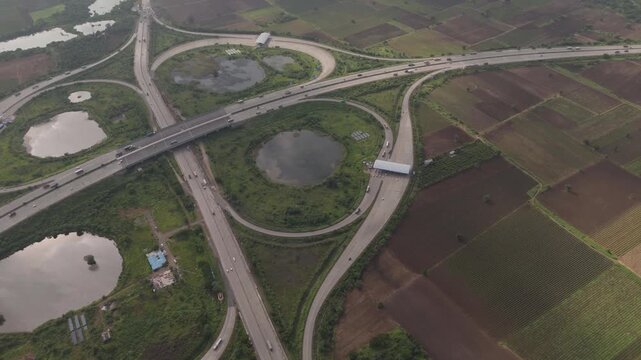 Aerial drone view of highway interchange and curved road network surrounded by agricultural fields in Bharuch Gujarat India