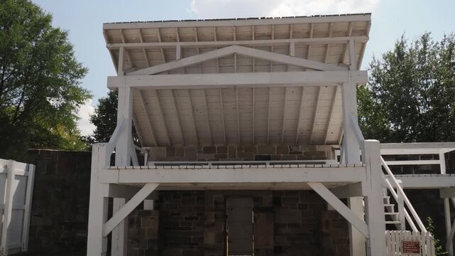White wooden gallows structure over stone ruins