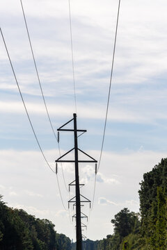 Tappahannock, Virginia, USA High tension electricity wires and pylons in a field through the woods.