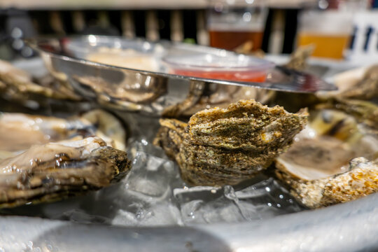 Solomons, Maryland USA A serving of a dozen raw oysters in their shell on ice with horseradish and hot sauce.