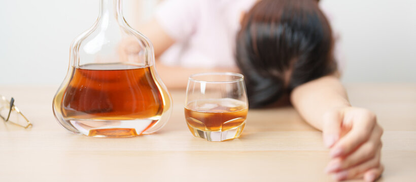 Stressed woman drinking cognac alone with problem. Exhausted drunk man looking stressed and sleepy. Alcohol addiction, Alcoholism, emotional distress and mental health concept