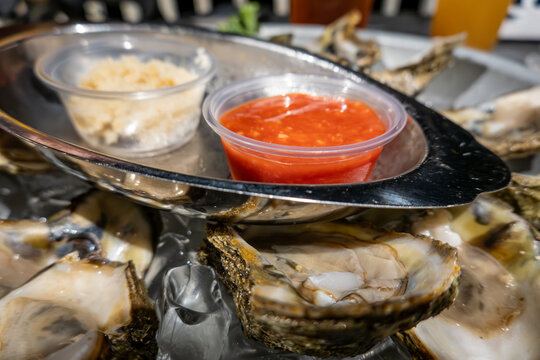 Solomons, Maryland USA A serving of a dozen raw oysters in their shell on ice with horseradish and hot sauce.