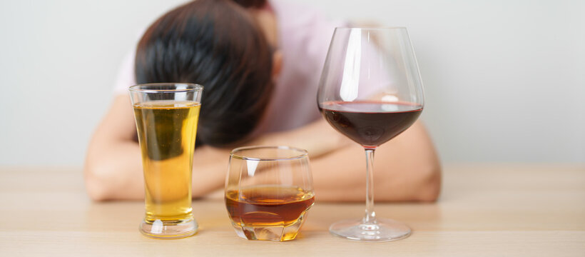 Stressed woman drinking wine, beer, whiskey or cognac alone with problem. Exhausted drunk woman looking stressed and sleepy. Alcohol addiction, Alcoholism, emotional distress and mental health