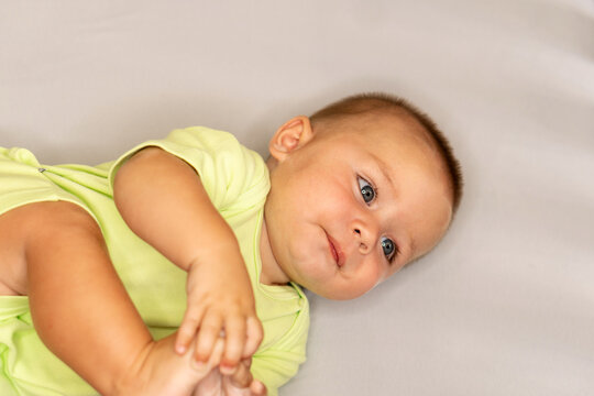 Curious Baby Boy Holding His Foot While Lying Down
