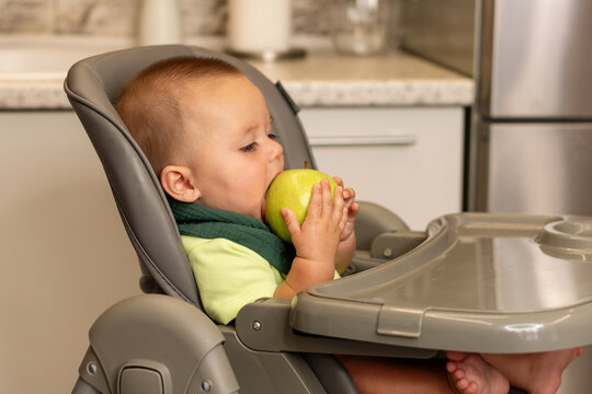 Baby Boy Bites Green Apple During Kitchen Mealtime