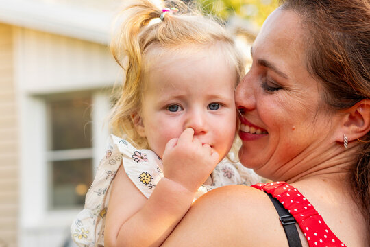 Mother Kissing Toddler Daughter During Playful Outdoor Moment