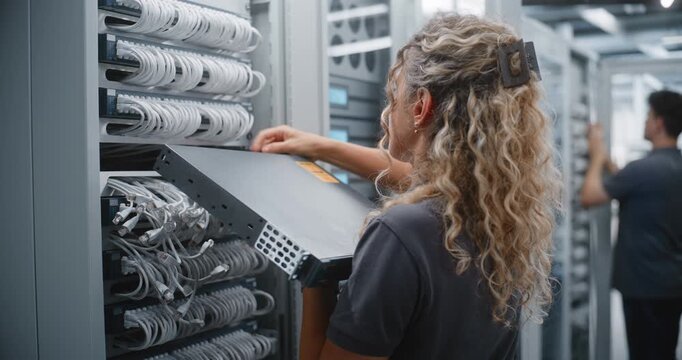 Female Data Center Engineer Installs New Network Switch Into Server Rack, Replacing Active Equipment and Organizing Hardware for Reliable Enterprise Connectivity and Efficient Network Service.