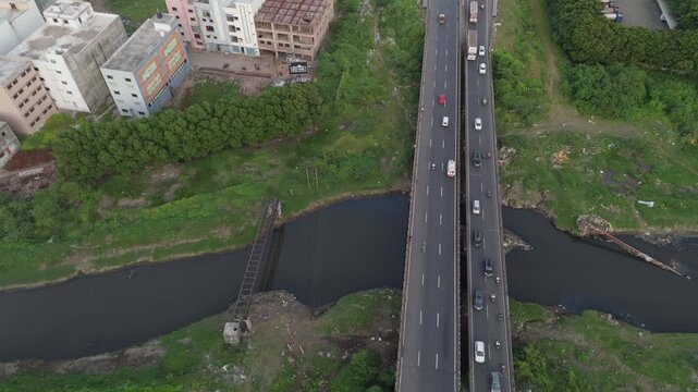 Top down aerial view of highway bridge crossing a waterway with moving vehicles in Surat Gujarat India