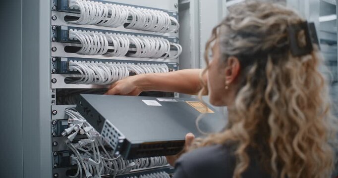 Female IT Specialist Replaces Rack Mounted Network Switch During Planned Infrastructure Upgrade, Positioning New Equipment Inside Server Cabinet to Support Stable Connectivity, Enterprise Operations.