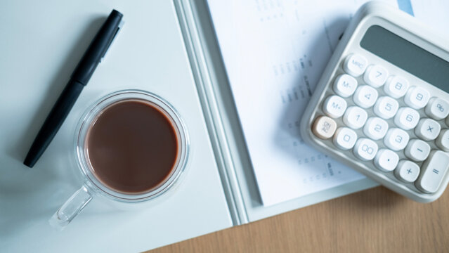Top view of coffee, calculator and pen on financial reports. Business accounting, budget calculation, investment analysis and financial planning concept.