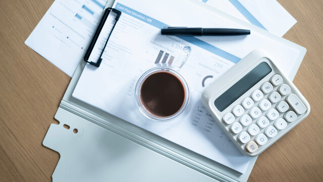 Top view of calculator, coffee and pen on financial documents. Business accounting, budget planning, investment analysis and finance management concept.