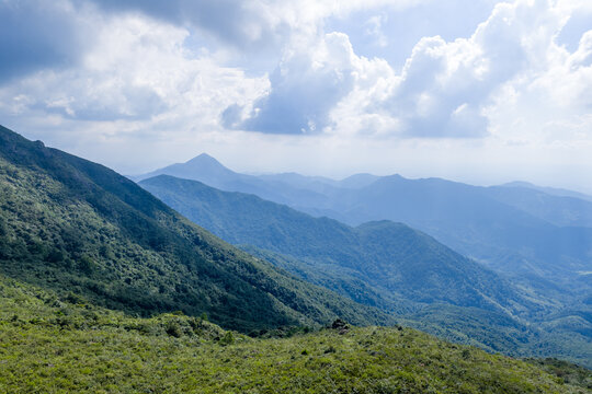 rolling green mountain ranges under blue sky with white clouds