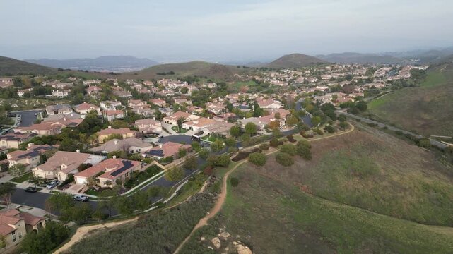 Aerial view passing overheard of upscale suburban homes in northern Thousand Oaks, heading towards the bridal path neighborhood of Simi Valley, California, on an overcast January day, 2024.