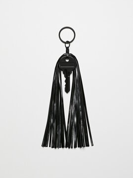 Black tassel keychain with metal keys on white background