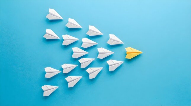 Yellow paper plane leading a group of white paper planes in a formation on a vibrant blue background representing leadership innovation and teamwork in business