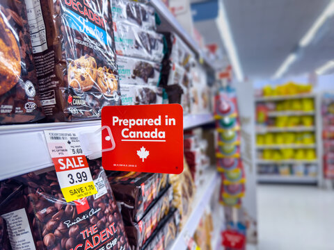 Calgary, AB, Canada - Sept 13, 2026: Close-up of a red "Prepared in Canada" sign on a store shelf displaying discounted chocolate chip cookies.