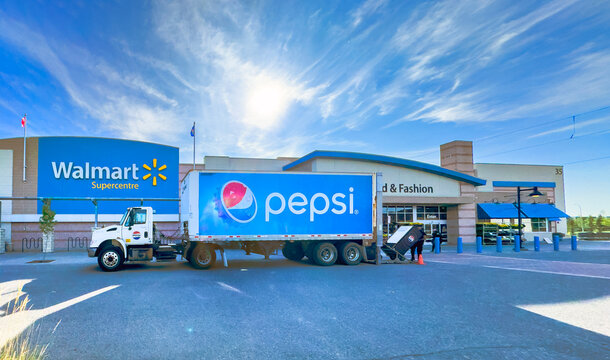 Calgary, AB, Canada. Sept 13, 2026. A Pepsi delivery semi-truck unloads merchandise outside a Walmart Supercentre building on a sunny day.