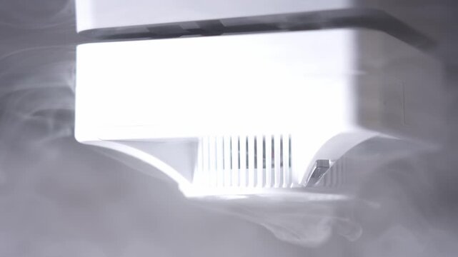 White appliance emerges from swirling water vapor