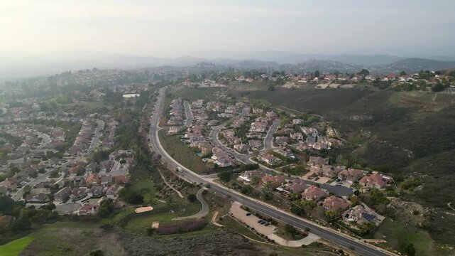 Aerial drone view moving left over upscale suburban homes in Thousand Oaks, California, on an overcast January day, 2024.