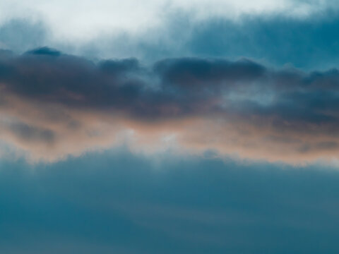 Dramatic Blue-Teal Storm Clouds with Warm Sunset Light Peeking Through