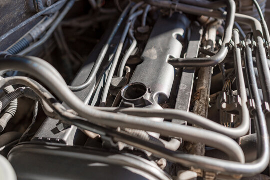 Close-up of a car engine with open oil filler cap during maintenance