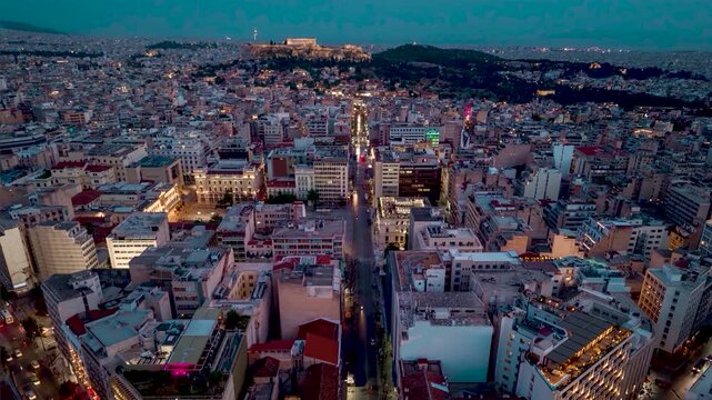 Aerial hyperlapse view of the city skyline from Omonia Square following Athinas Street until the Acropolis during dusk