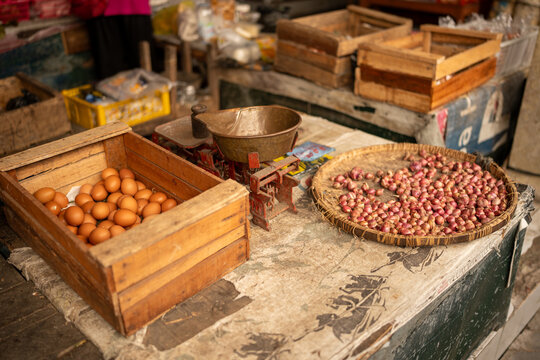 Market stall selling fresh eggs and shallots with scale