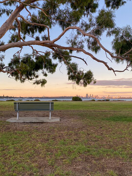 Park bench viewing perth city skyline at sunset