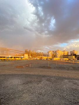 Industrial processing plant at sunset with dramatic sky