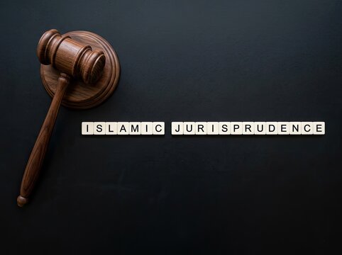 Wooden gavel beside Islamic Jurisprudence text suitable for legal and religious editorial content symbolizing sharia law authority and justice