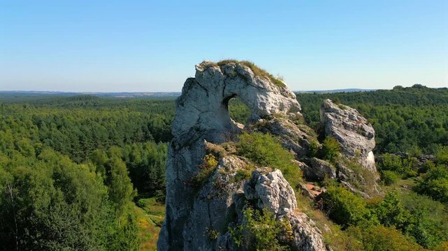 Aerial view of natural rock arch at Maczuga Herkulesa in southern Poland. Unique limestone formation surrounded by forest in the Jura region.