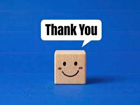 Smiley face wooden cube with thank you speech bubble perfect for customer appreciation media symbolizing gratitude and satisfaction